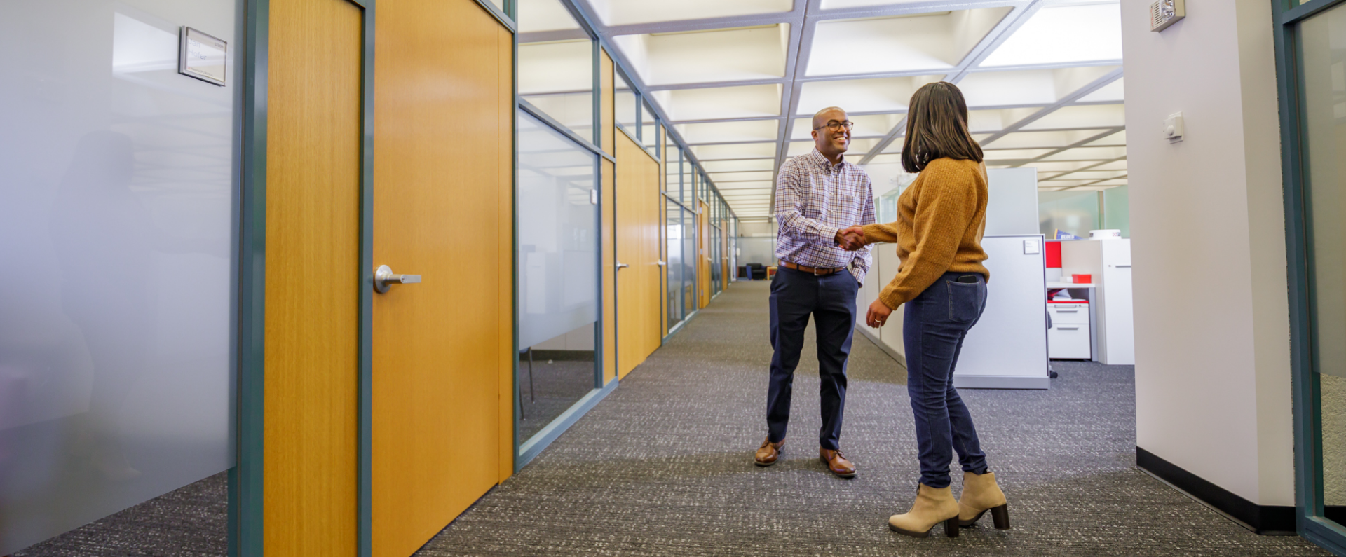 2 purina employees shaking hands in hallway
